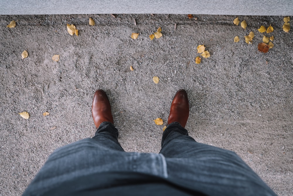person in black denim jeans and brown leather shoes
