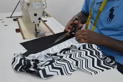 person in blue and white shirt holding black and white textile