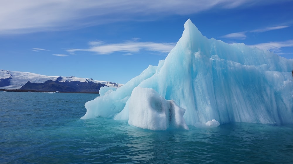 white ice formation on sea under blue sky during daytime