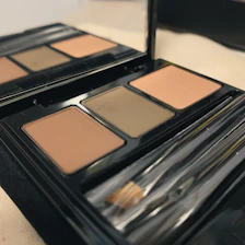 A warm, inviting makeup studio with soft beige and toasted sand tones accented by a pop of blue.