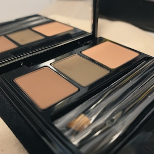 A palette of contour powders arranged artistically with soft lighting highlighting their rich tones.