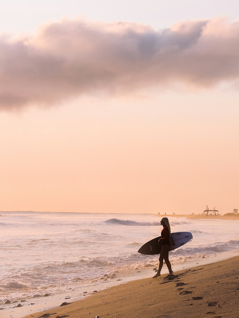 man in black wet suit carrying white surfboard walking on beach during daytime