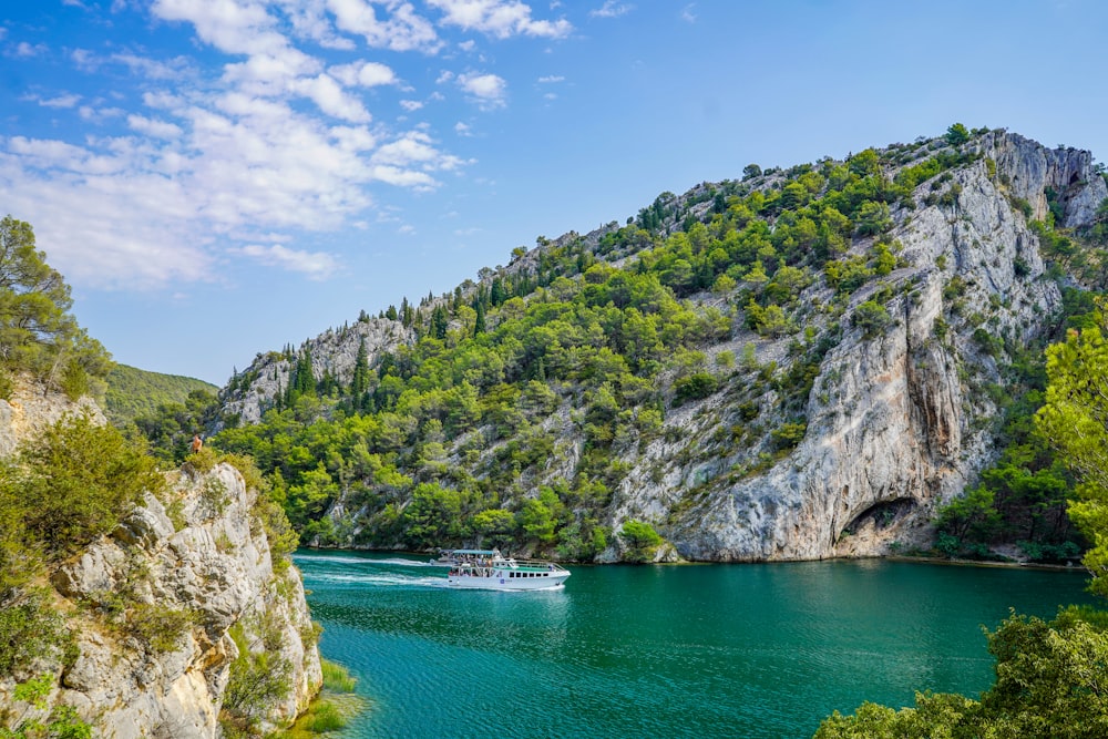 green body of water near mountain during daytime