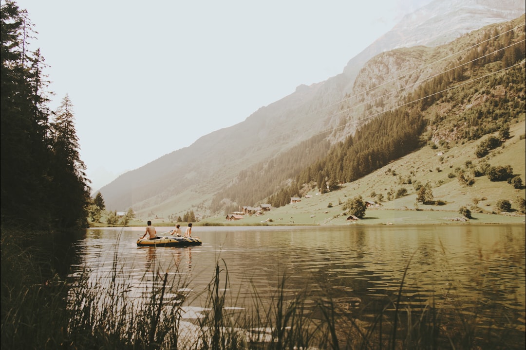 brown boat on lake near mountain during daytime