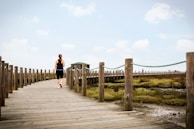 couple walking on wooden bridge during daytime