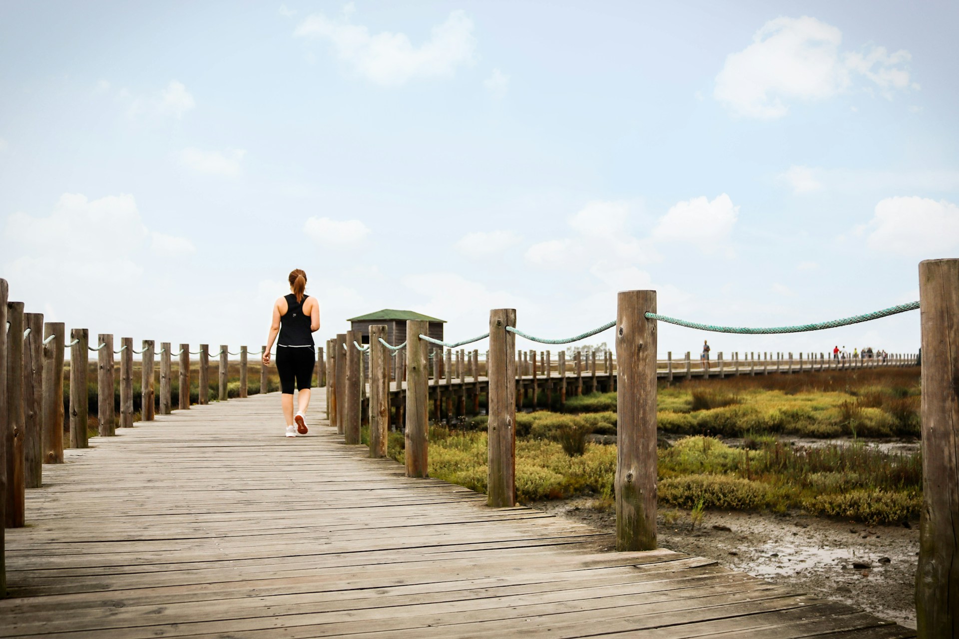 couple walking on wooden bridge during daytime