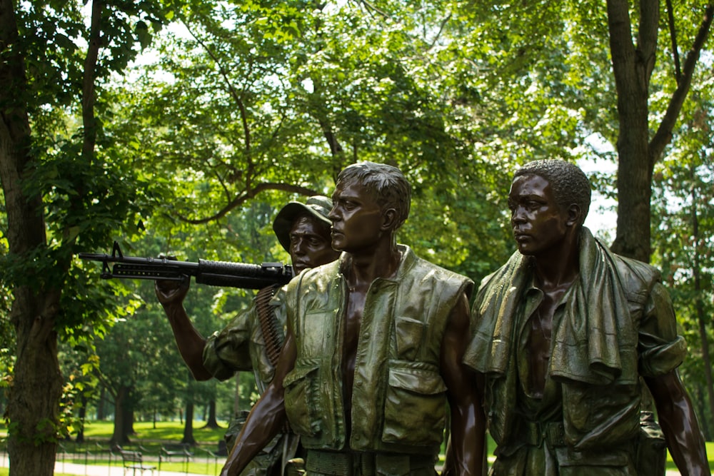 hommes en uniforme de camouflage tenant un fusil