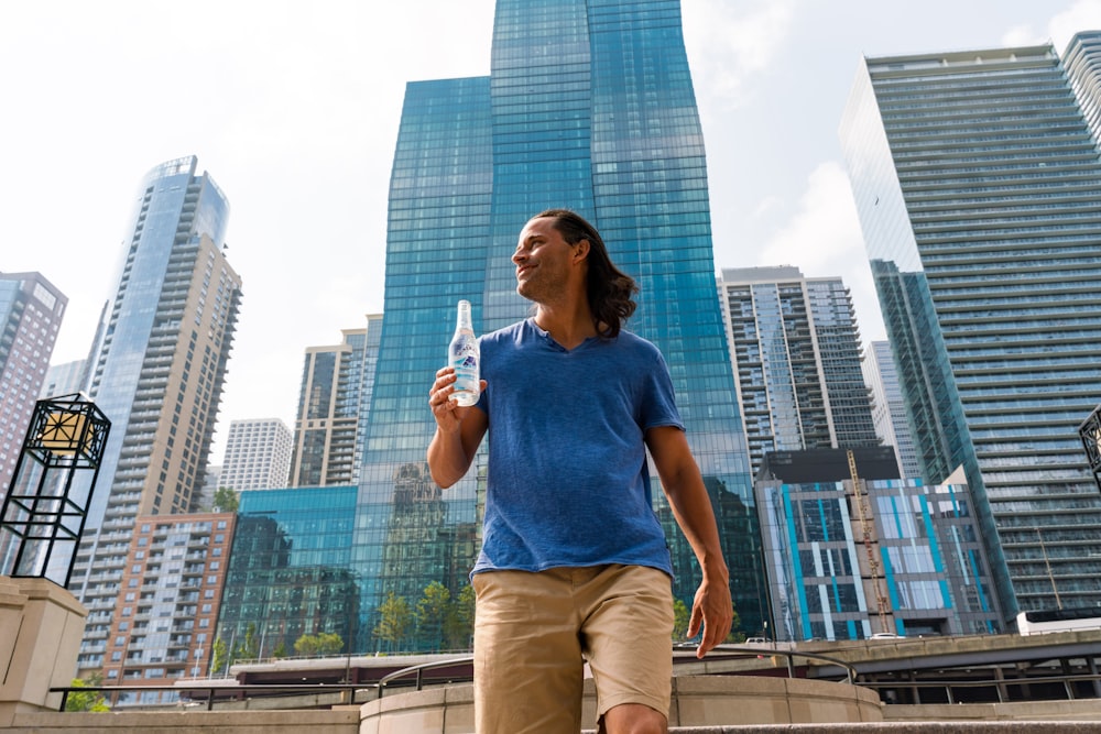 woman in blue tank top and brown pants standing on top of building during daytime