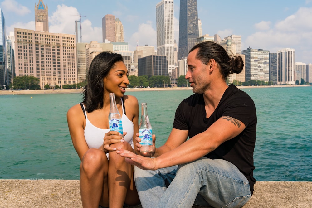 woman in black tank top and blue denim jeans sitting beside woman in black tank top