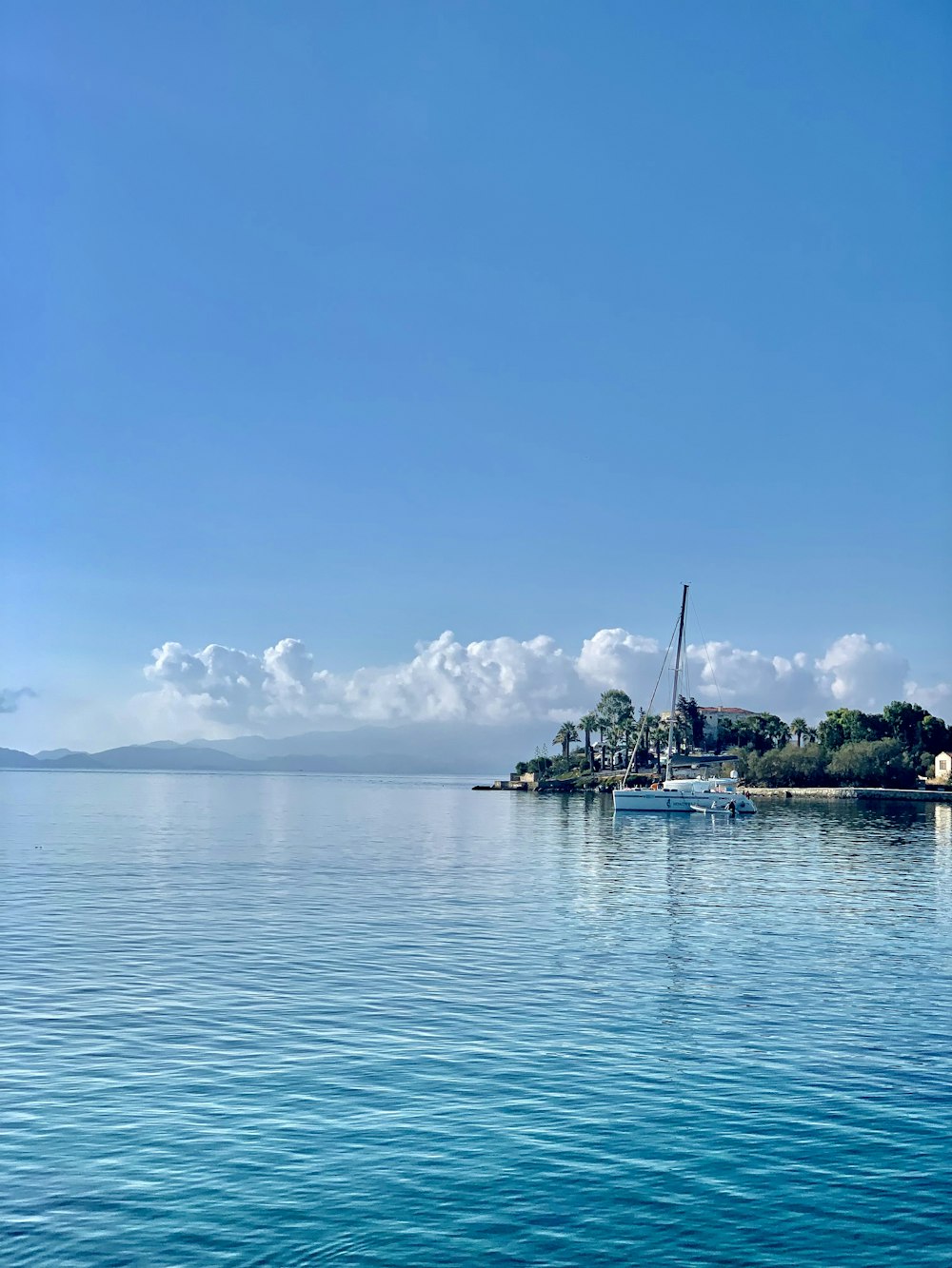 white boat on sea under blue sky during daytime