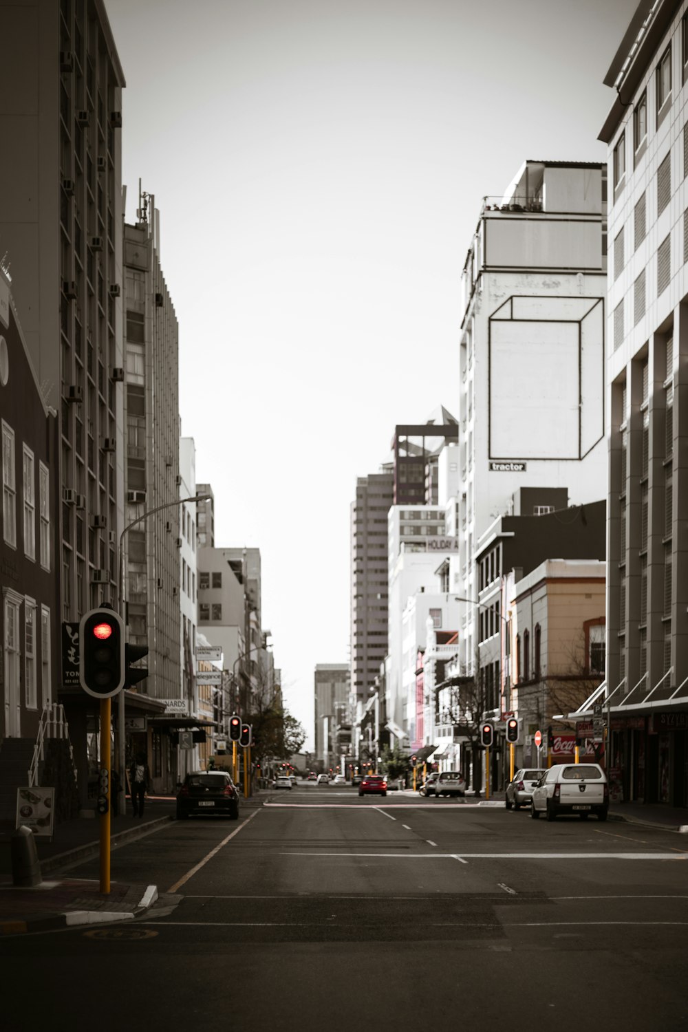 cars on road between high rise buildings during daytime