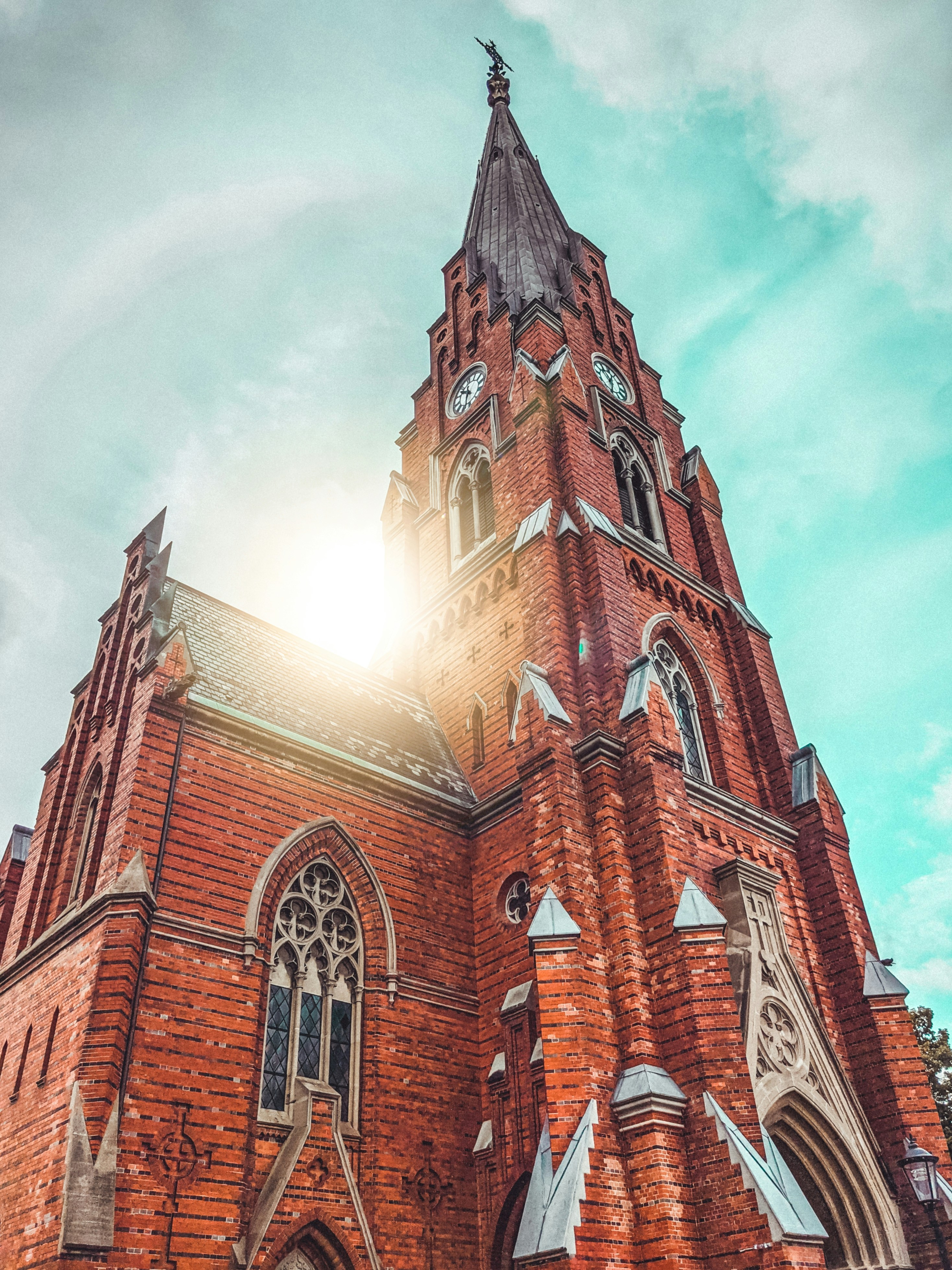 bâtiment en béton brun sous des nuages blancs pendant la journée