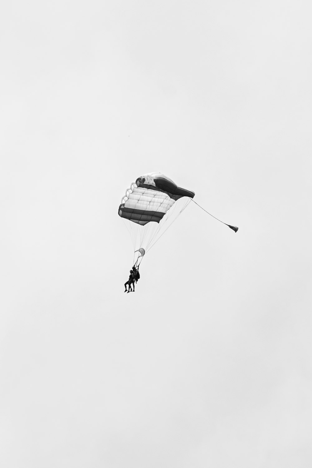 person in parachute in grayscale photography