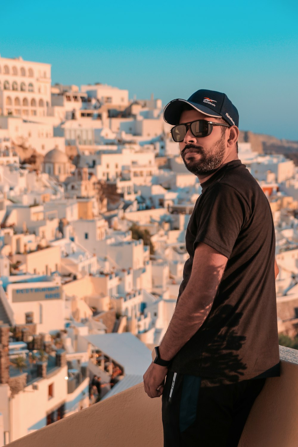 man in black crew neck t-shirt wearing black sunglasses and black cap