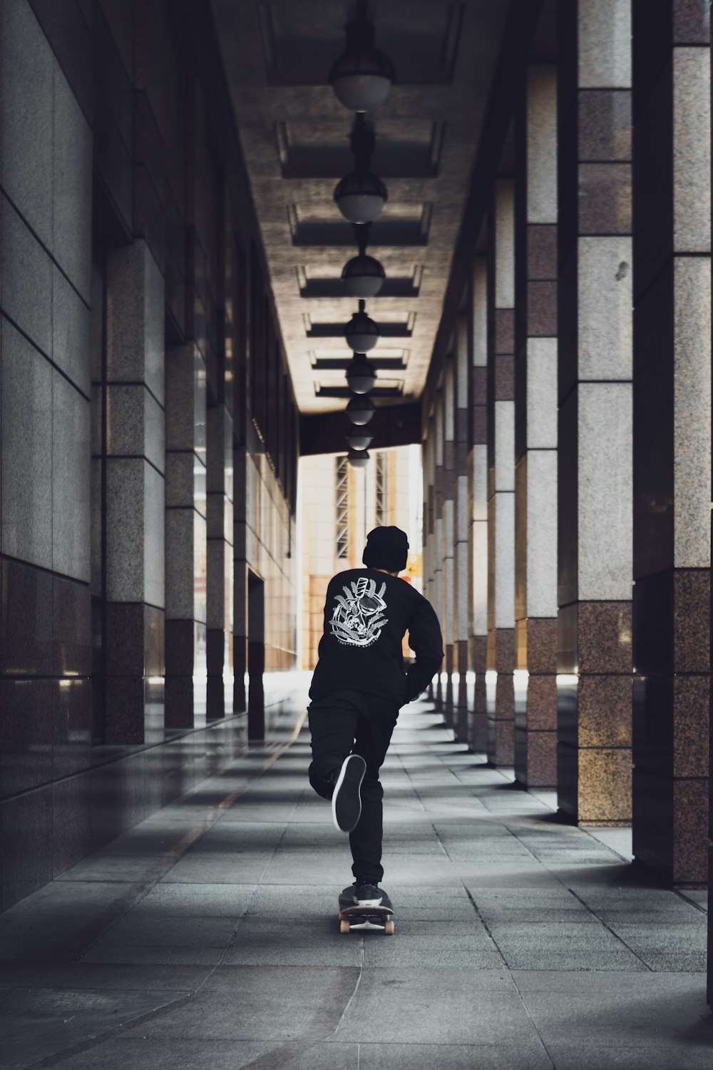 man in black and yellow hoodie walking on hallway