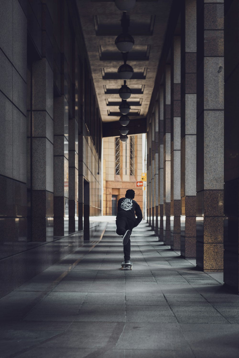 homme en veste noire marchant sur le couloir