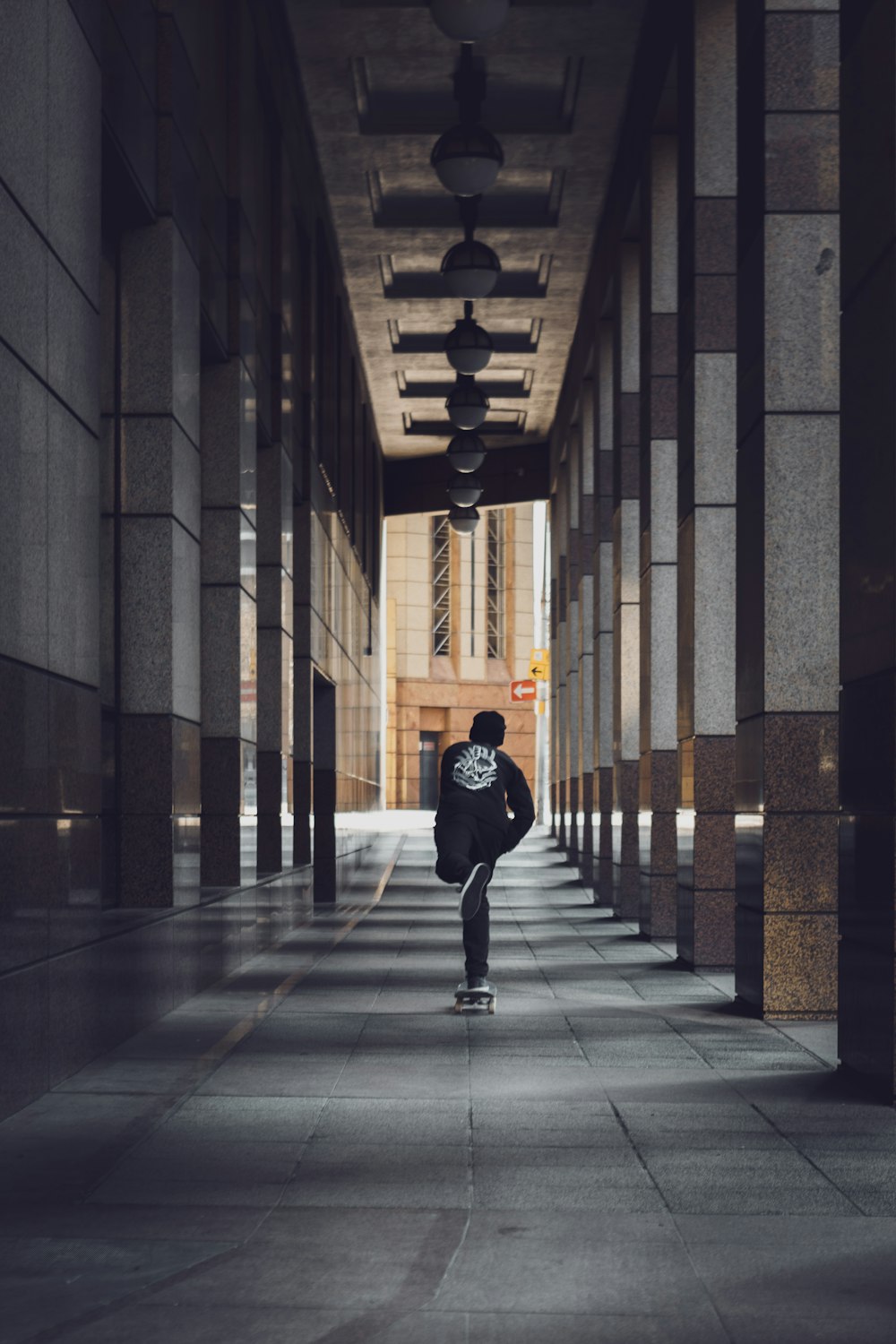 man in black jacket walking on hallway