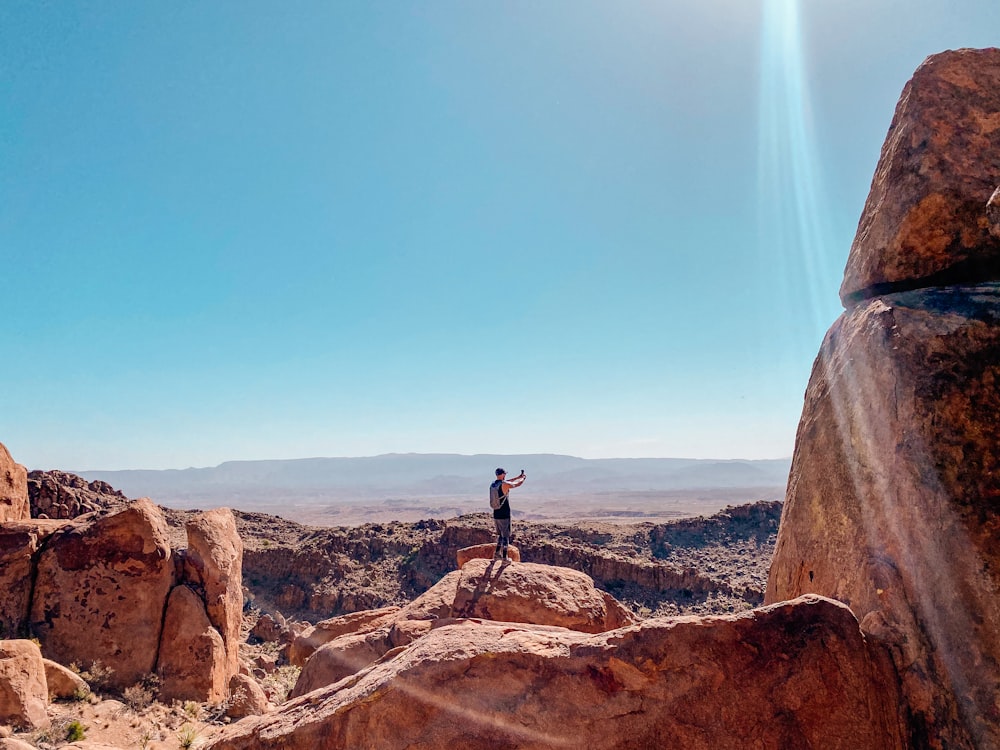 person standing on brown rock formation during daytime