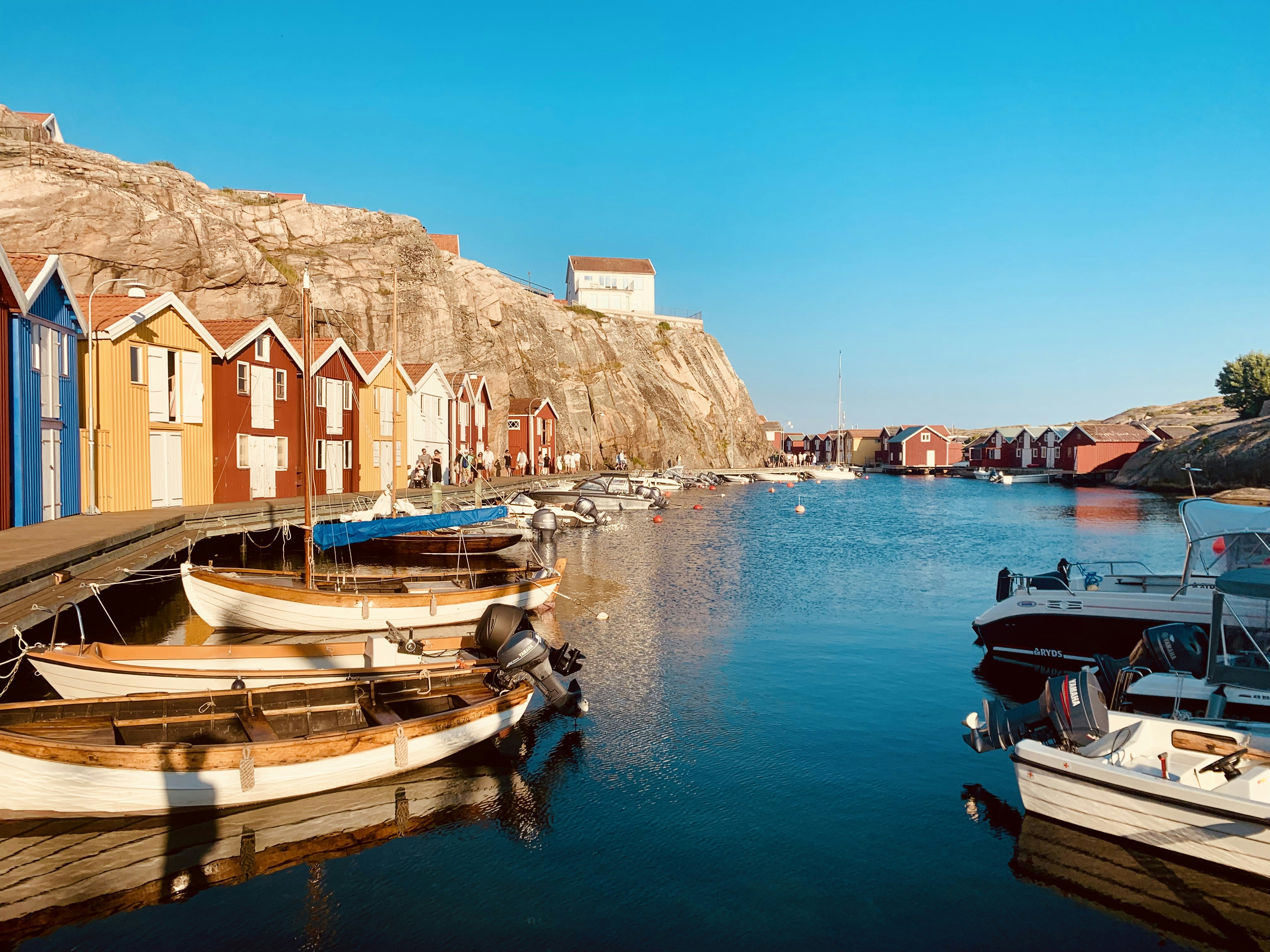 日中、茶色のコンクリートの建物の近くで水上に浮かぶボート