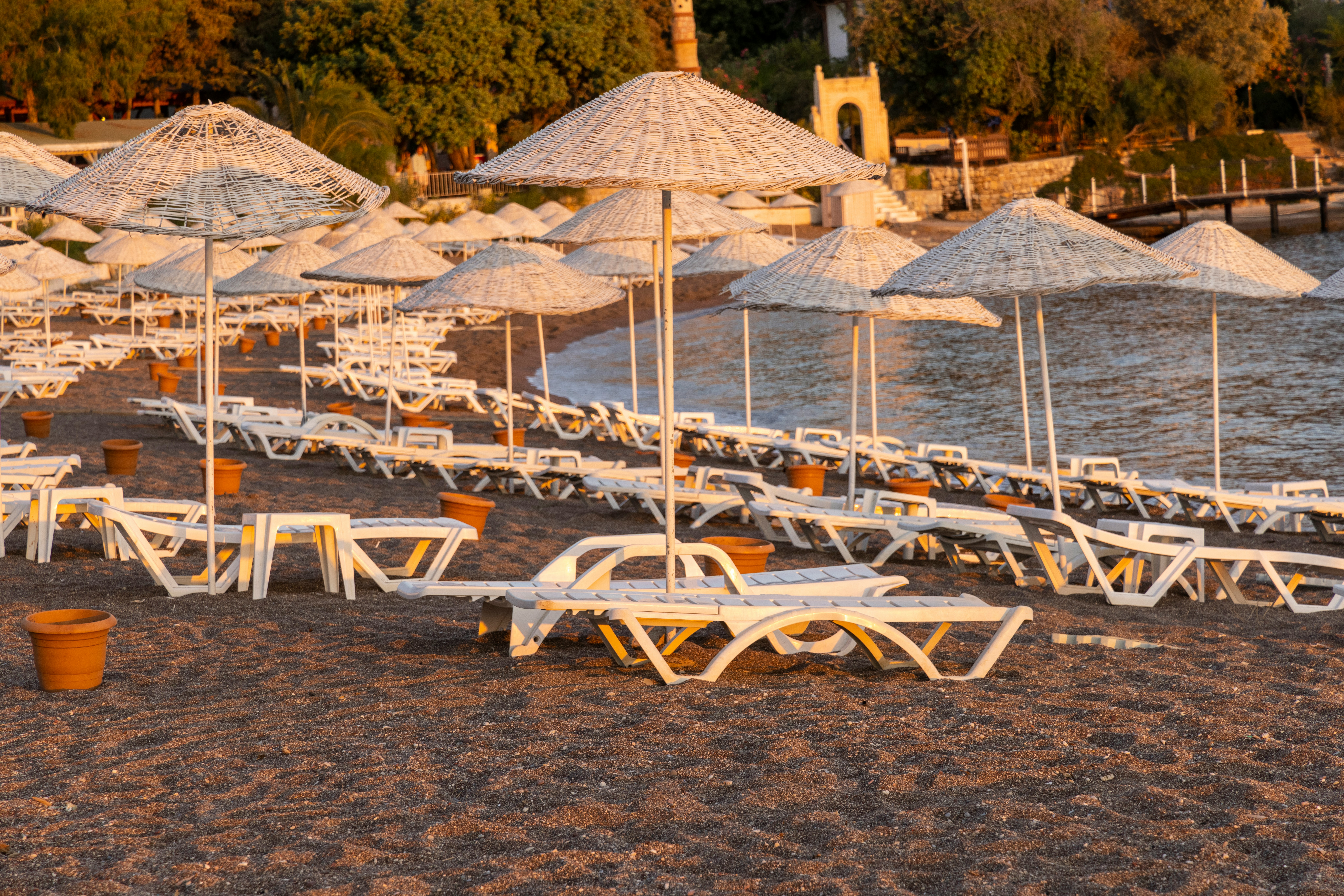 white and brown wooden lounge chairs on beach during daytime