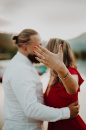 woman in red shirt kissing man in white dress shirt