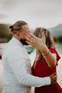 woman in red shirt kissing man in white dress shirt