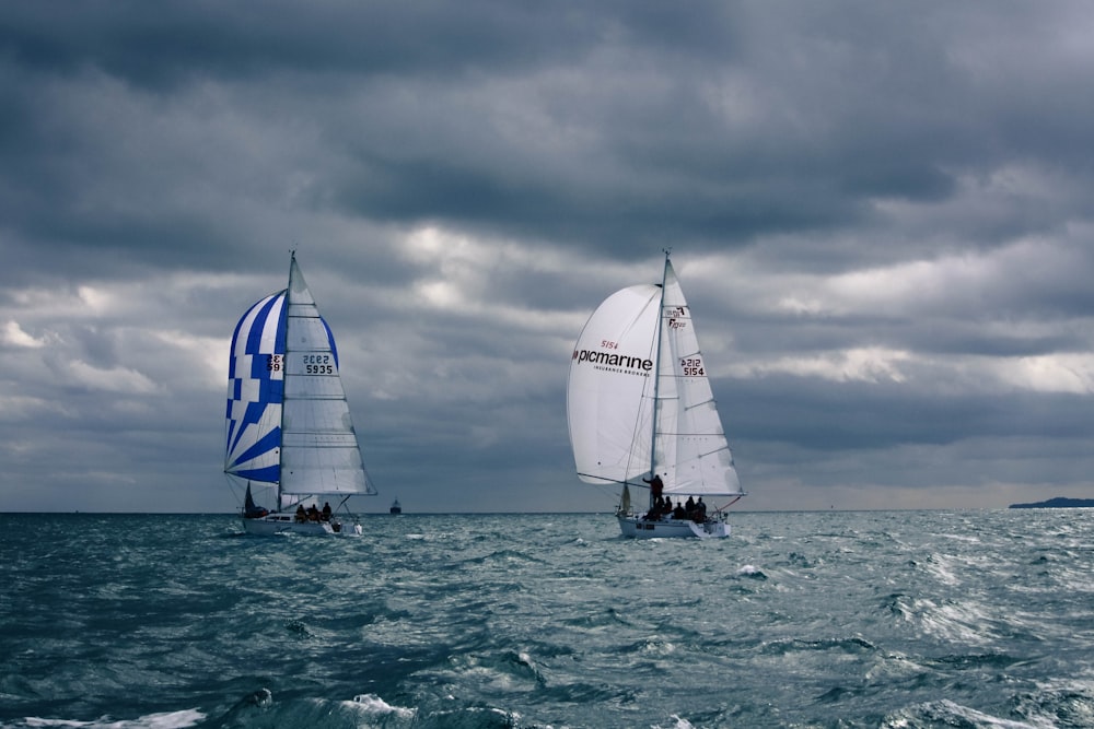 white sail boat on sea under cloudy sky during daytime