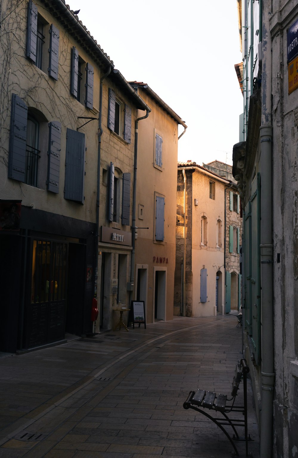 empty street between concrete buildings during daytime