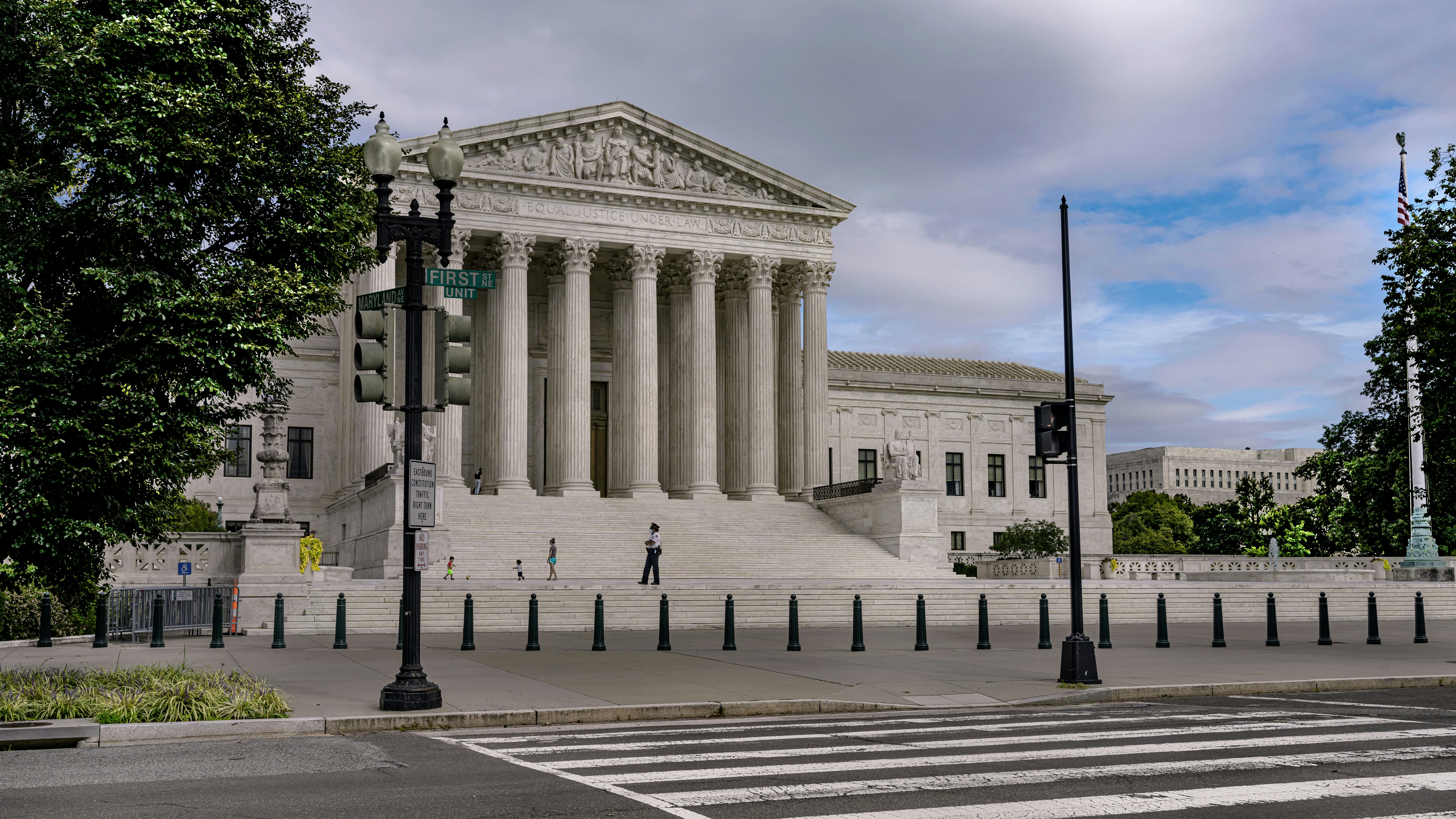 people walking on gray concrete pathway near white concrete building during daytime