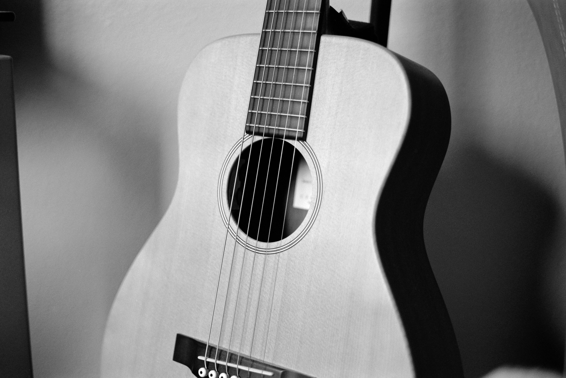 black acoustic guitar on white textile