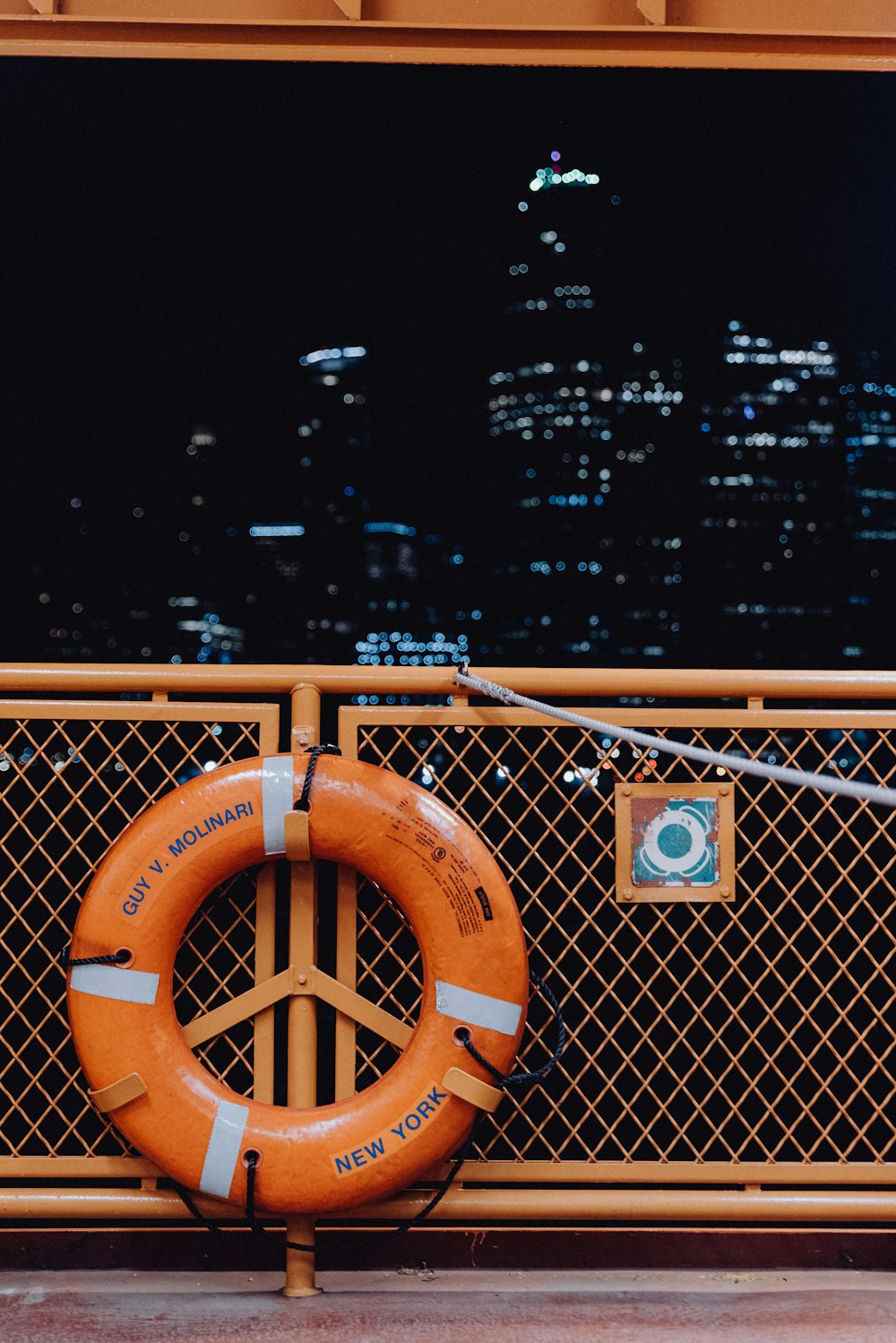 orange metal fence with city view during night time