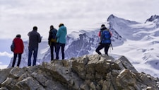 group of people standing on gray rock formation during daytime