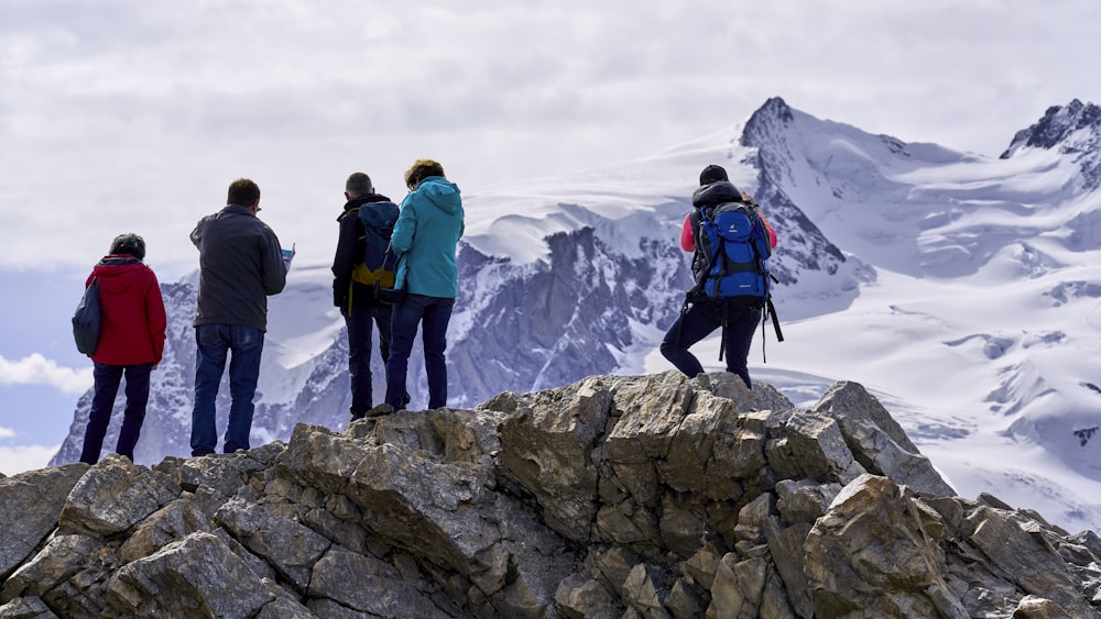 group of people standing on gray rock formation during daytime