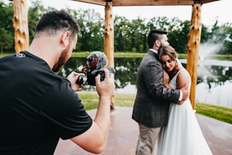 man in black t-shirt holding black dslr camera