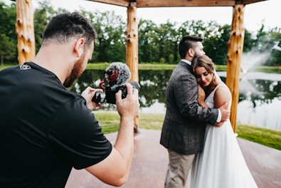 man in black t-shirt holding black dslr camera