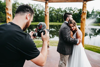 man in black t-shirt holding black dslr camera