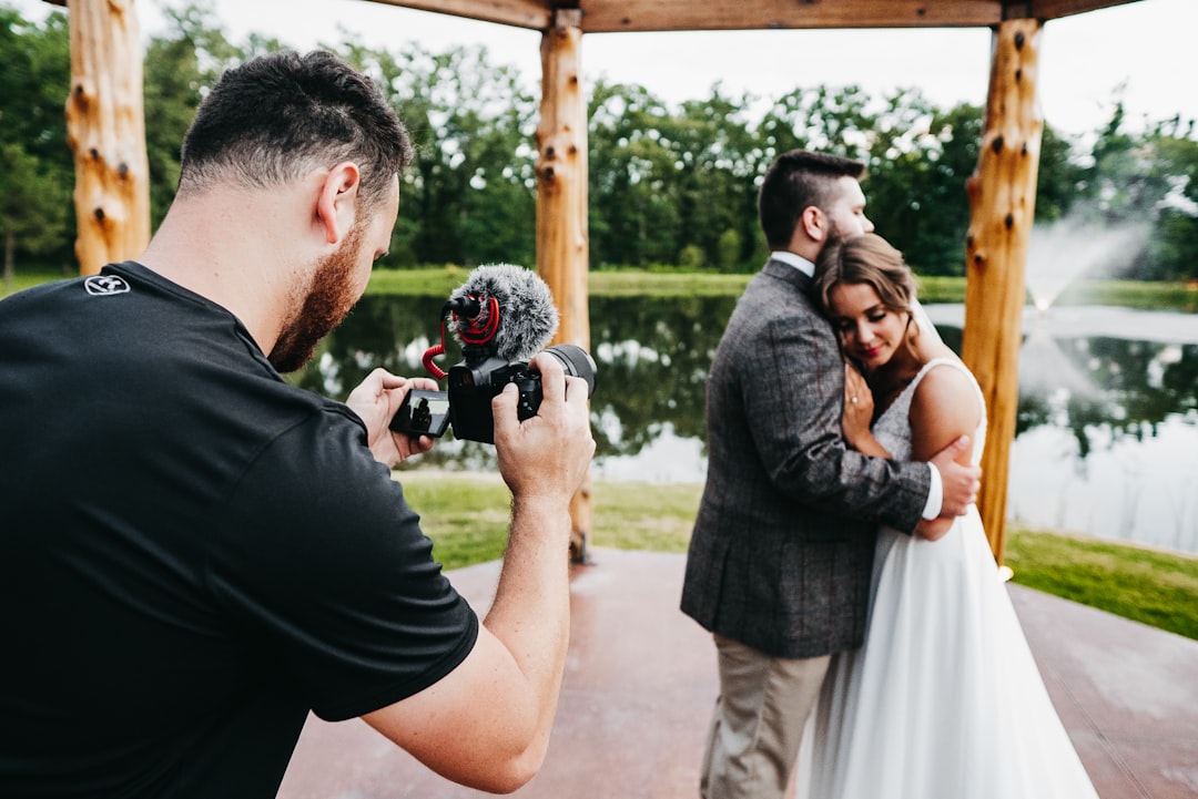 man in black t-shirt holding black dslr camera