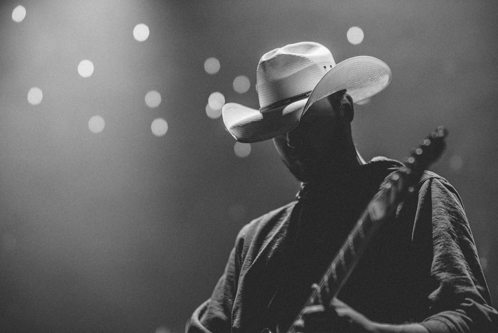 man in black jacket and white cowboy hat