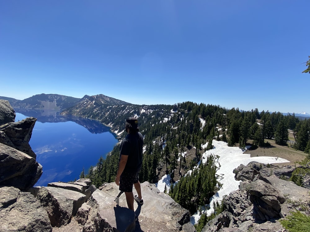 person sitting on rock near body of water during daytime