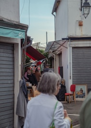 Jane and her aunt sharing a quiet moment on a bustling Finch street filled with colorful market stalls.