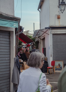 Jane and her aunt sharing a quiet moment on a bustling Finch street filled with colorful market stalls.