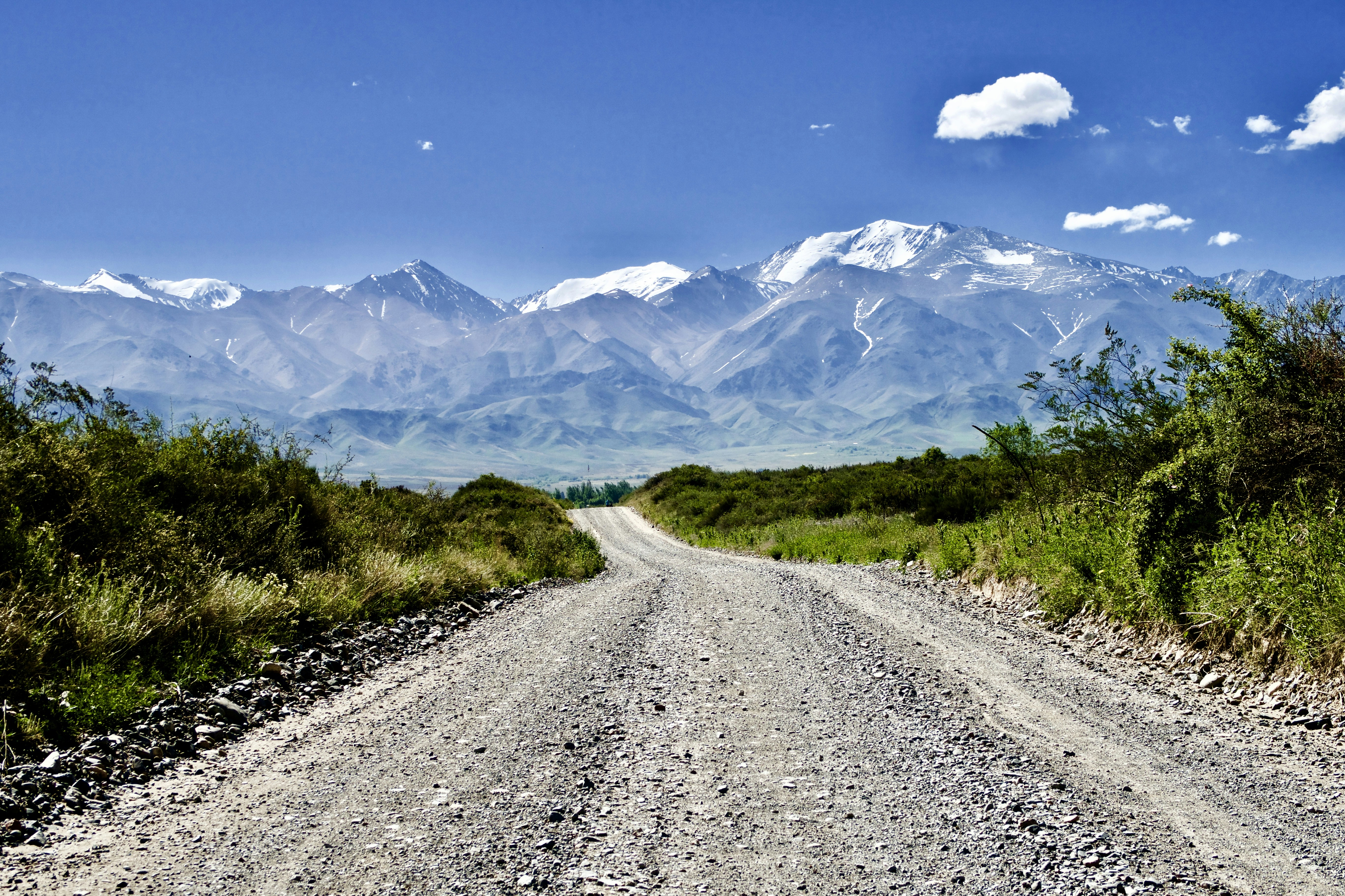 green grass field near mountain under blue sky during daytime, 