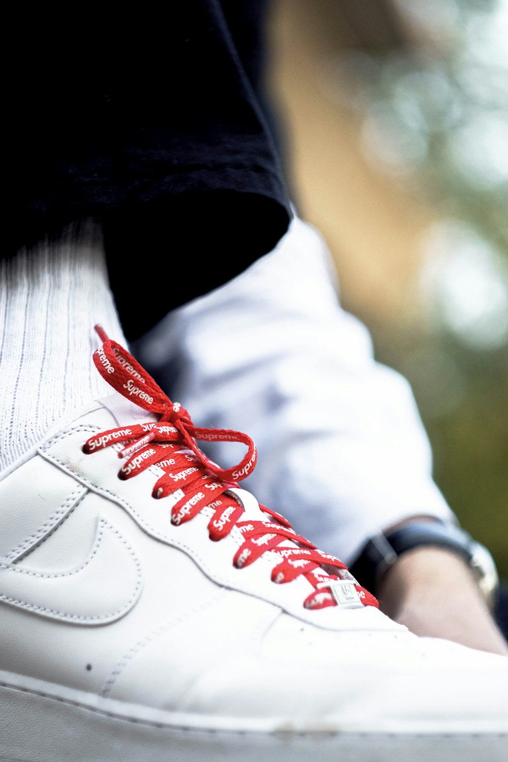 person wearing white and red nike sneakers