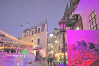 A lively street scene where a host guides visitors through Medellín’s hidden cultural spots at sunset.