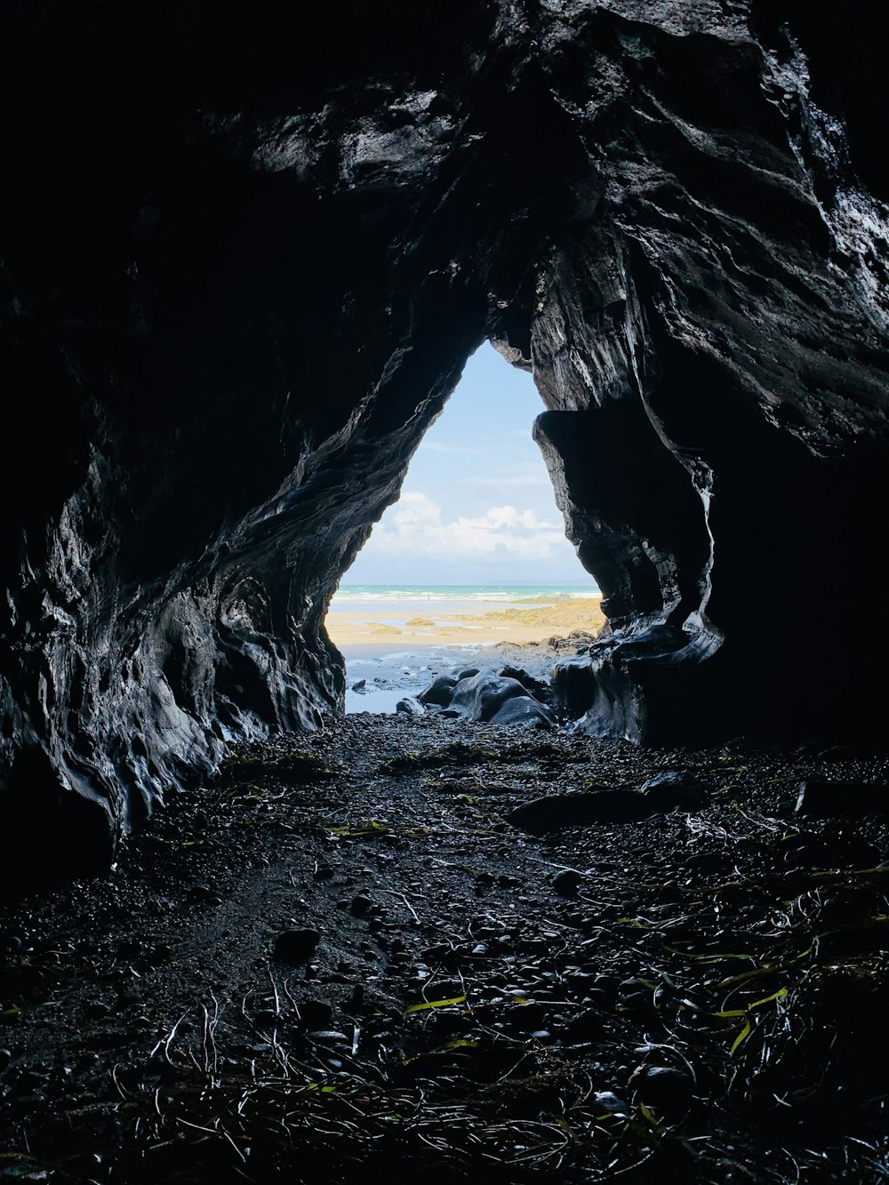 black rock formation near body of water during daytime