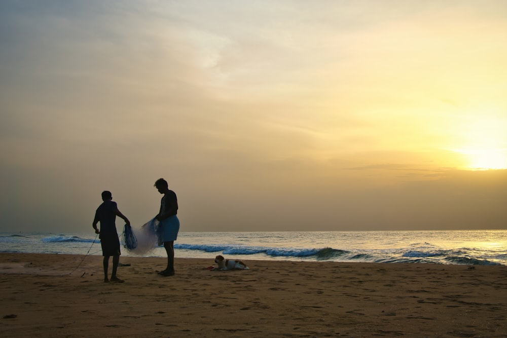 homem e mulher que caminham na praia durante o pôr do sol