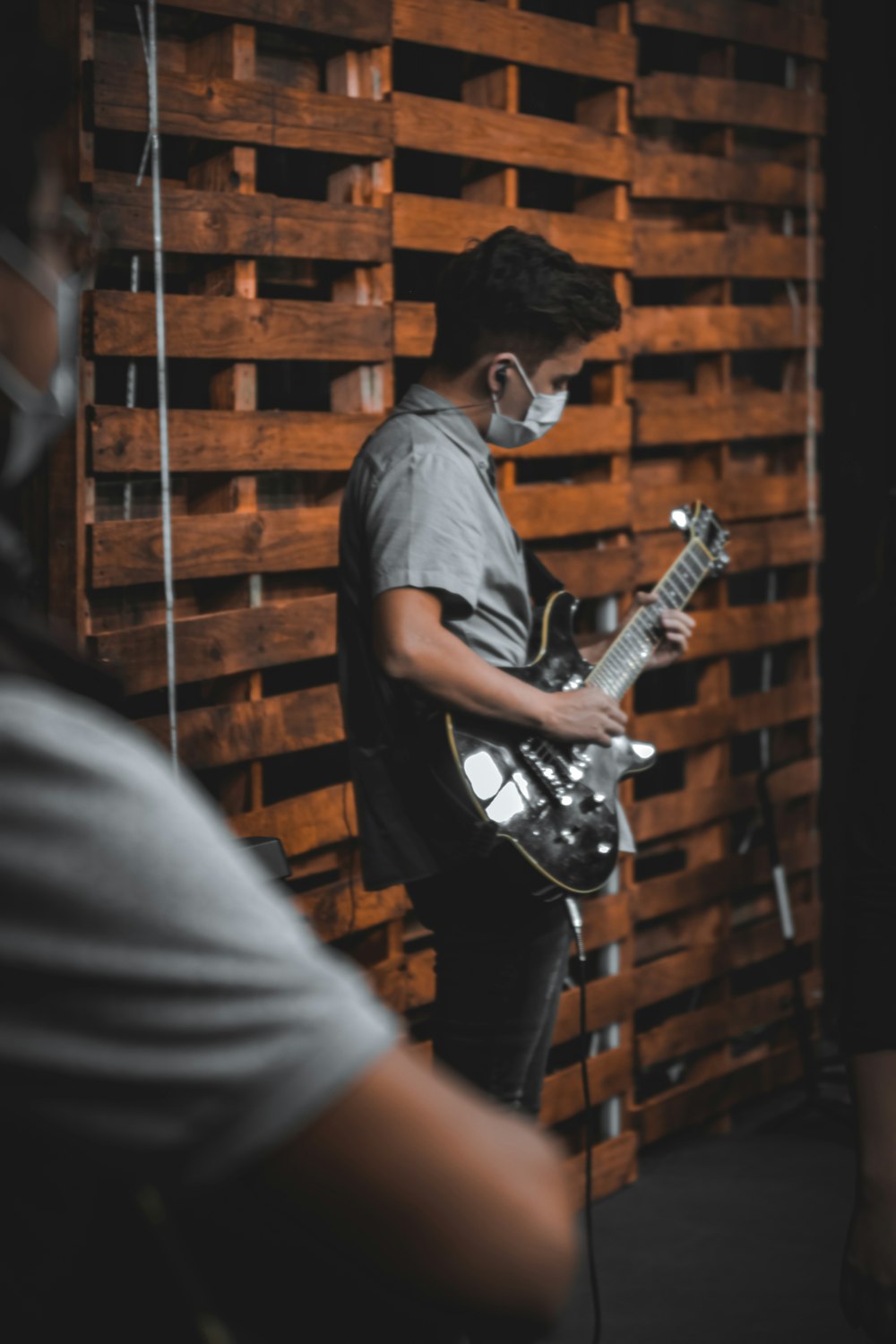 man in blue polo shirt playing electric guitar