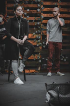 A close-up of hands exchanging a microphone on a rustic wooden table with Jujuy mountains in the background
