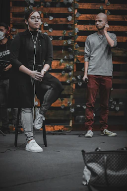A close-up of hands exchanging a microphone on a rustic wooden table with Jujuy mountains in the background