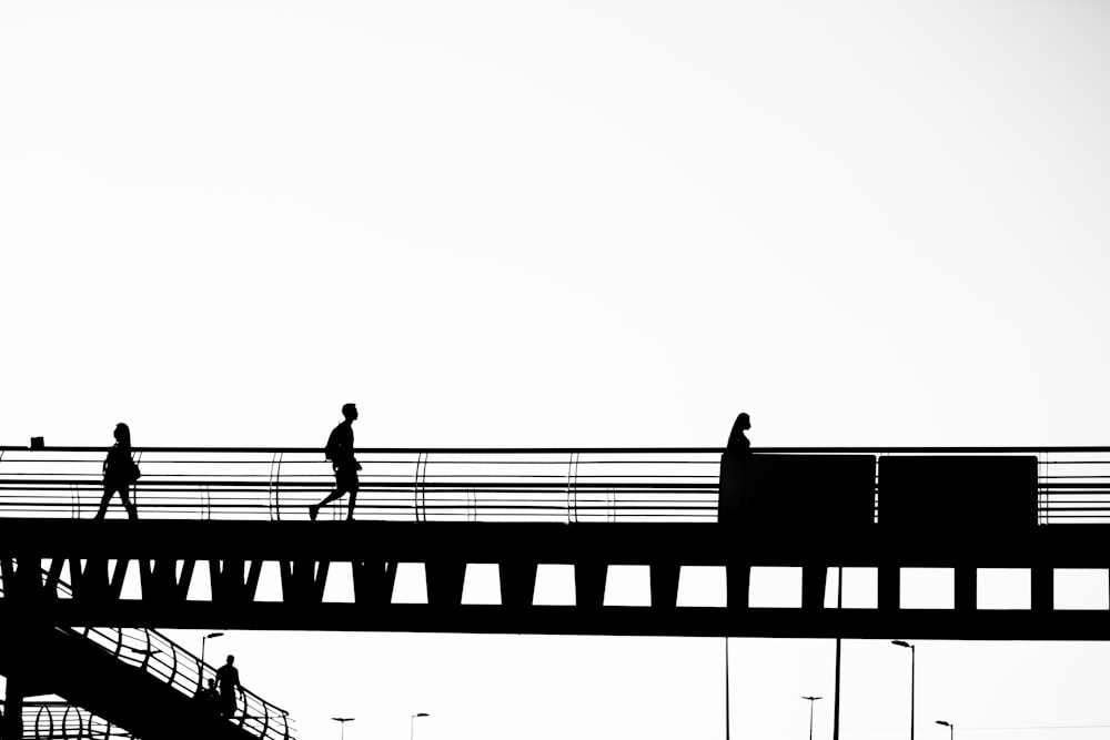 silhouette of man standing on bridge